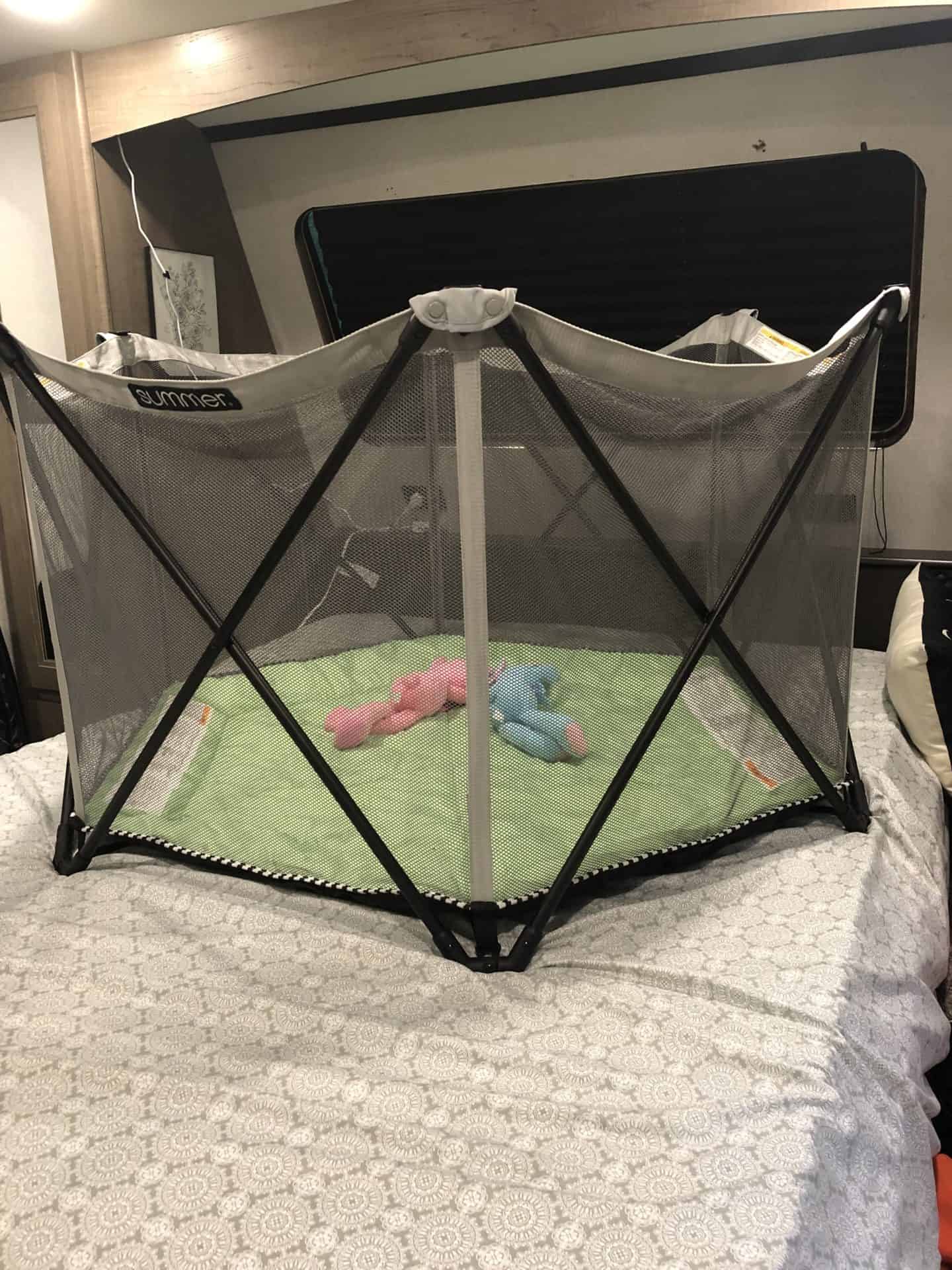 camping with toddlers, playpen sitting on top of bed