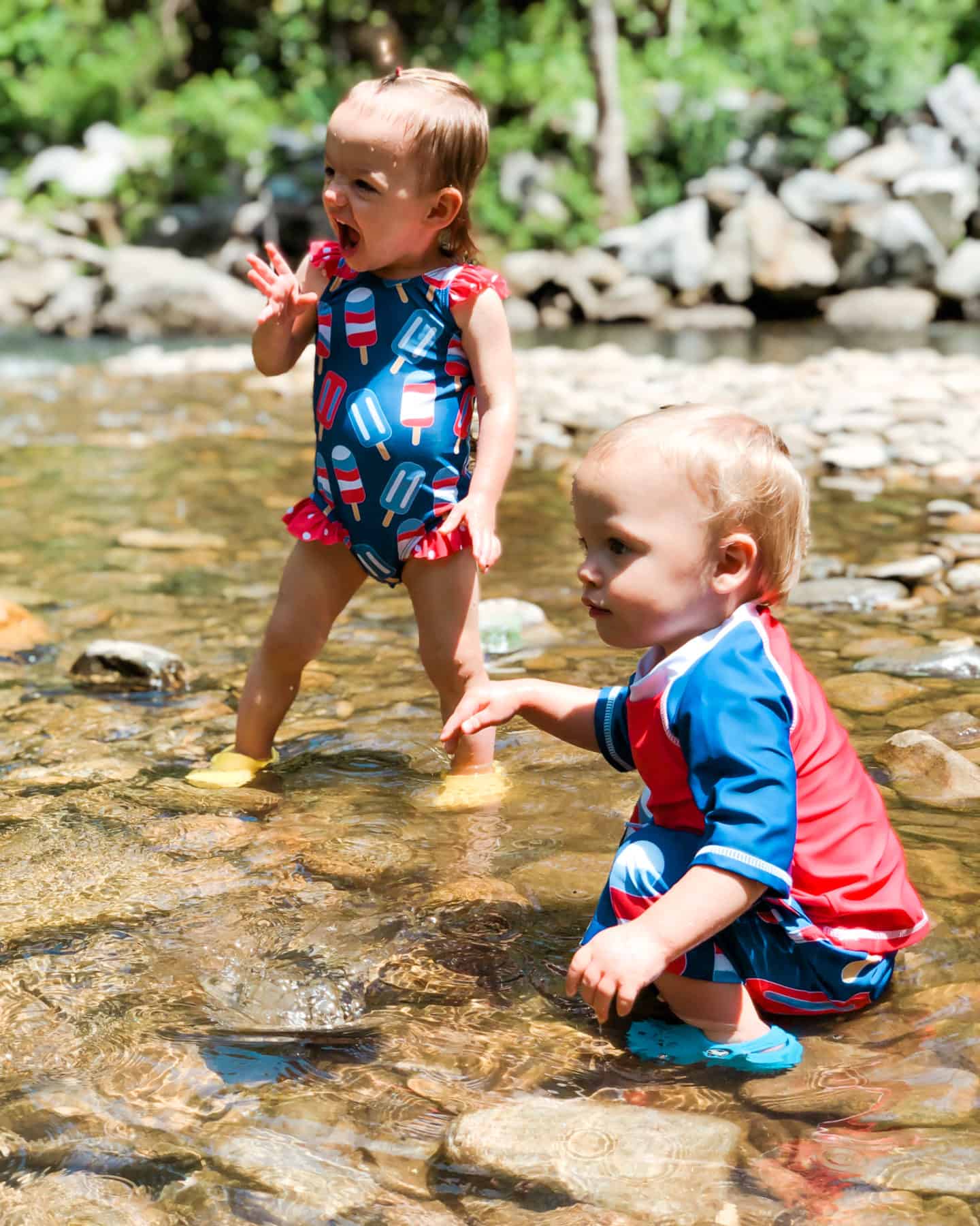 camping with toddlers, boy and girl sitting in river